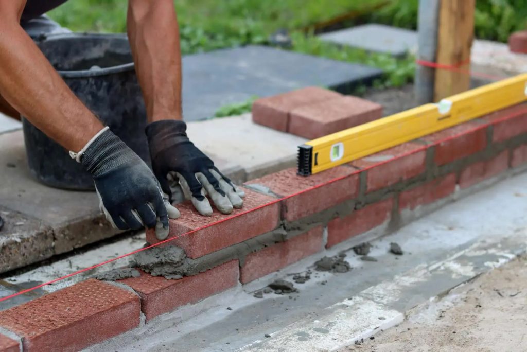 New brick being laid with a level on a chimney rebuild